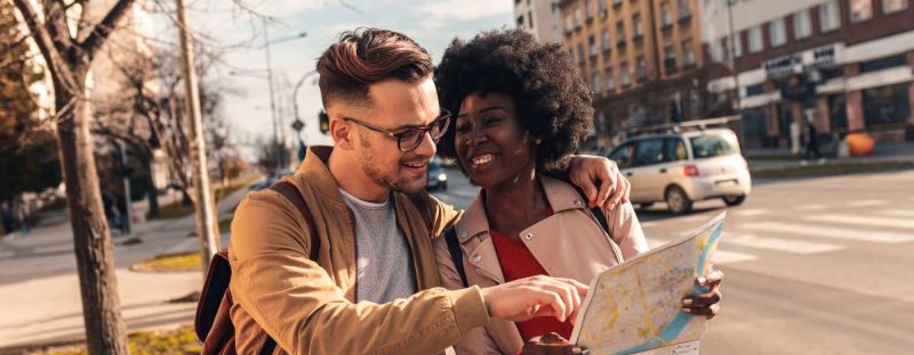 a man and woman looking at a map in the city
